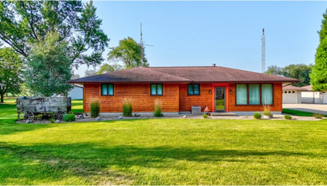 back of house featuring a garage, central AC unit, and a lawn