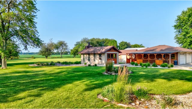 view of front of home featuring covered porch, a front lawn, and an attached garage