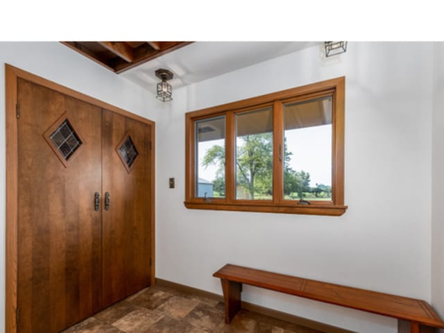 entrance foyer featuring stone finish floor and baseboards