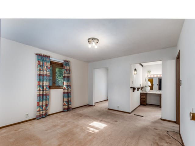 unfurnished bedroom with carpet, connected bathroom, and baseboards