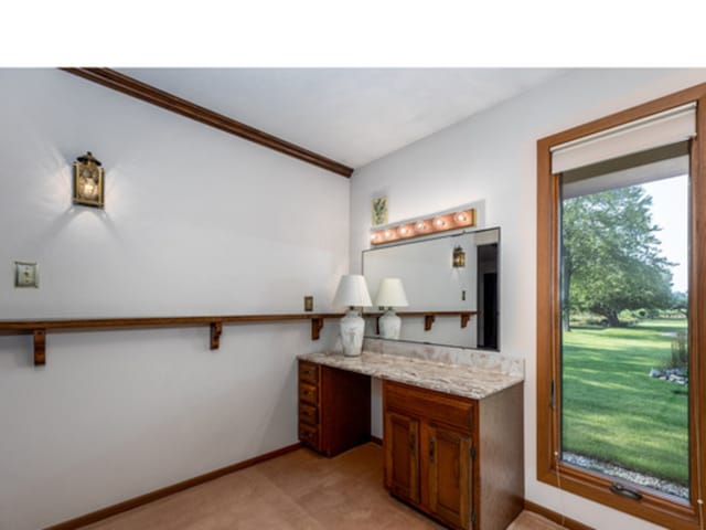 office featuring ornamental molding, light carpet, baseboards, and built in study area