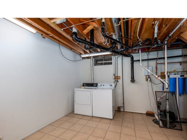 washroom featuring laundry area, light tile patterned flooring, and separate washer and dryer