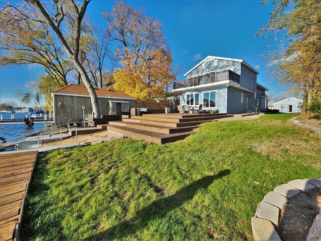 dock area with a deck with water view and a yard