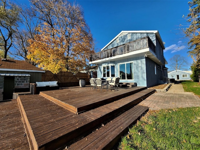 back of house featuring a patio, outdoor dining space, fence, an outdoor living space, and a wooden deck