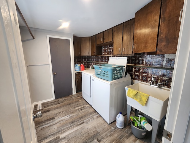 laundry area with cabinets, sink, light hardwood / wood-style flooring, and washer and dryer