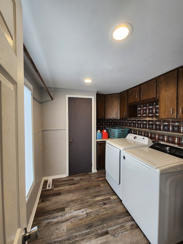 washroom featuring cabinets, washer and dryer, and dark hardwood / wood-style floors