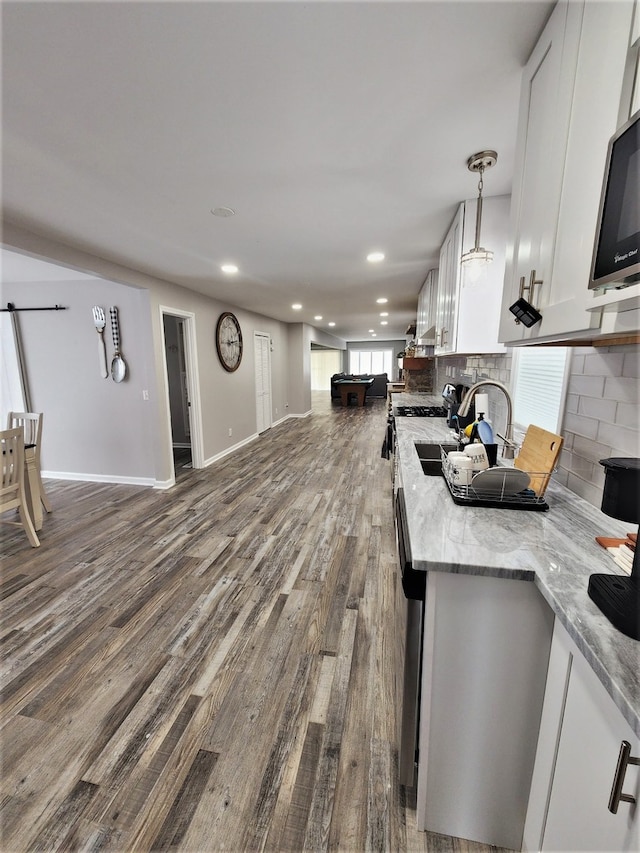 kitchen featuring hardwood / wood-style floors, white cabinetry, tasteful backsplash, and a wealth of natural light