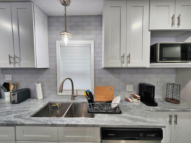 kitchen with tasteful backsplash, hanging light fixtures, white cabinets, sink, and dishwasher