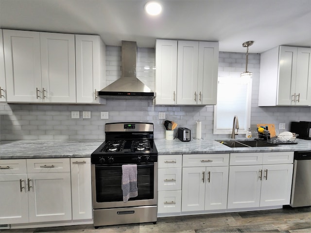 kitchen featuring white cabinets, appliances with stainless steel finishes, wall chimney exhaust hood, wood-type flooring, and sink