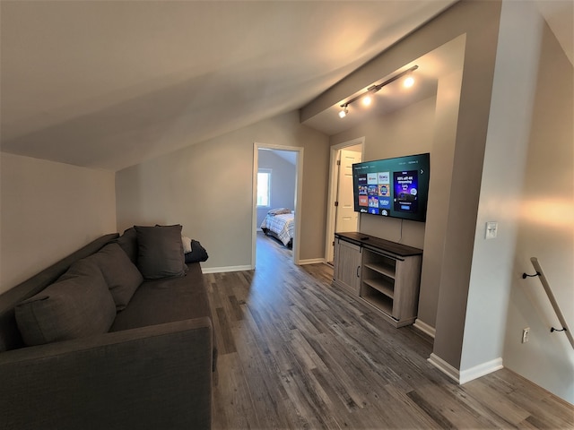 living room with lofted ceiling, track lighting, and hardwood / wood-style floors