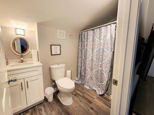 full bath featuring visible vents, a shower with shower curtain, toilet, wood finished floors, and vanity