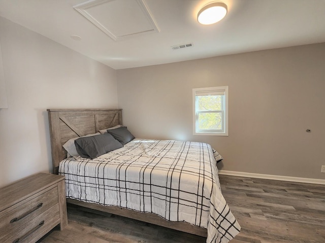 bedroom with baseboards, dark wood finished floors, visible vents, and attic access