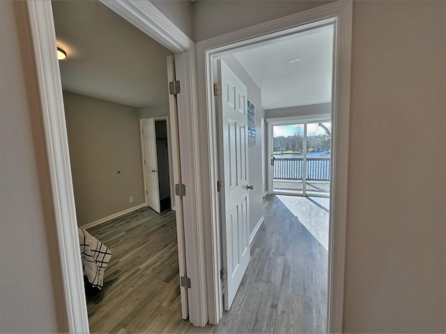 corridor with light wood-style flooring and baseboards