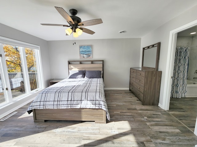 bedroom featuring dark wood-type flooring, ensuite bath, and ceiling fan