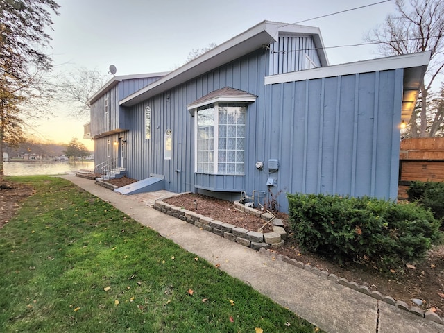 back house at dusk with a lawn