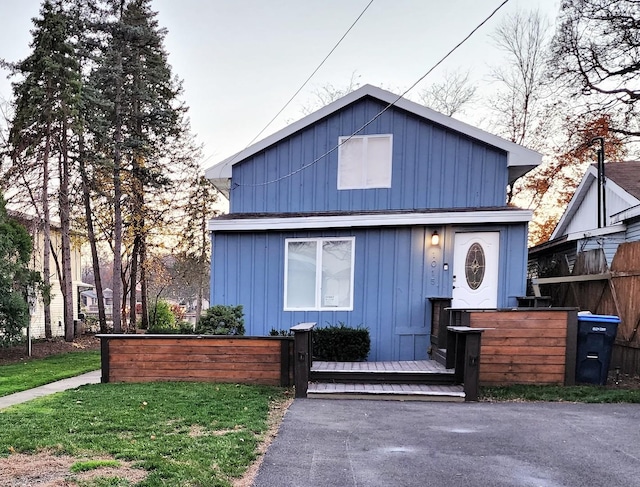 view of front facade featuring fence, board and batten siding, and a front yard