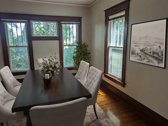 dining area with hardwood / wood-style flooring and crown molding