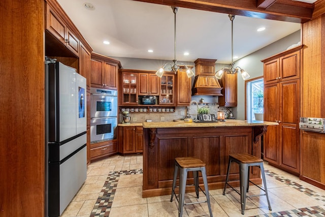 kitchen with stainless steel appliances, a kitchen breakfast bar, hanging light fixtures, light tile patterned flooring, and custom range hood