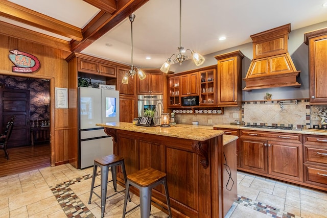 kitchen with a center island, beam ceiling, a breakfast bar area, and appliances with stainless steel finishes