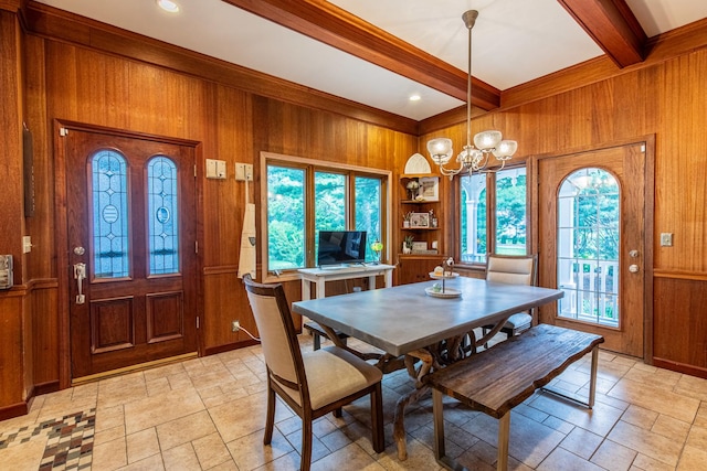 dining area with built in features, beamed ceiling, wood walls, and a notable chandelier