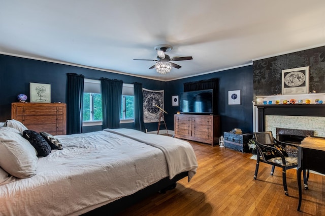 bedroom with crown molding, hardwood / wood-style flooring, and ceiling fan