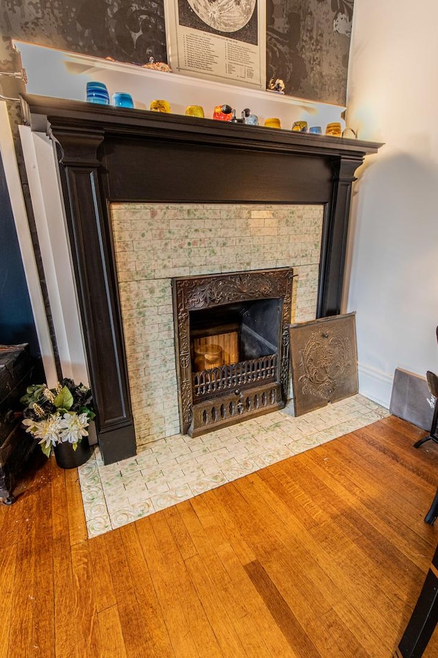 details with a tile fireplace and hardwood / wood-style flooring