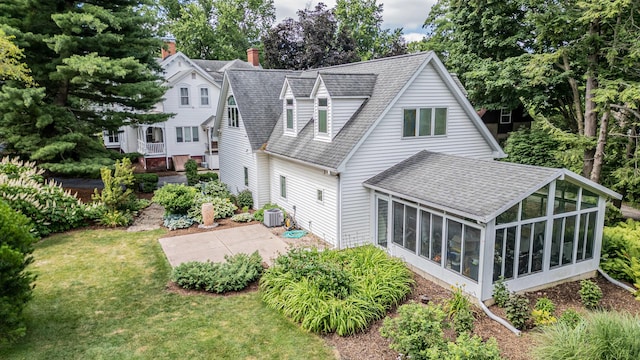 back of property featuring central AC unit, a sunroom, a patio area, and a yard