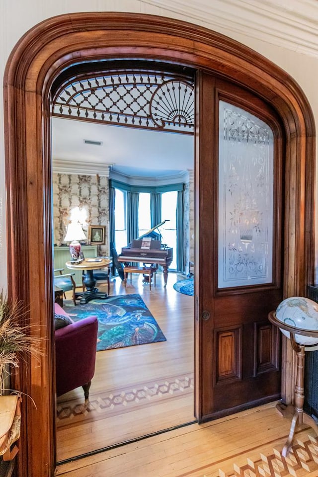 entryway with light hardwood / wood-style flooring and ornamental molding