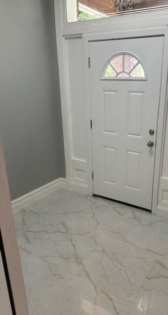 foyer featuring marble finish floor and baseboards