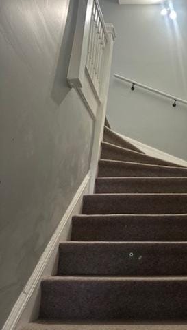 staircase with baseboards and wood finished floors