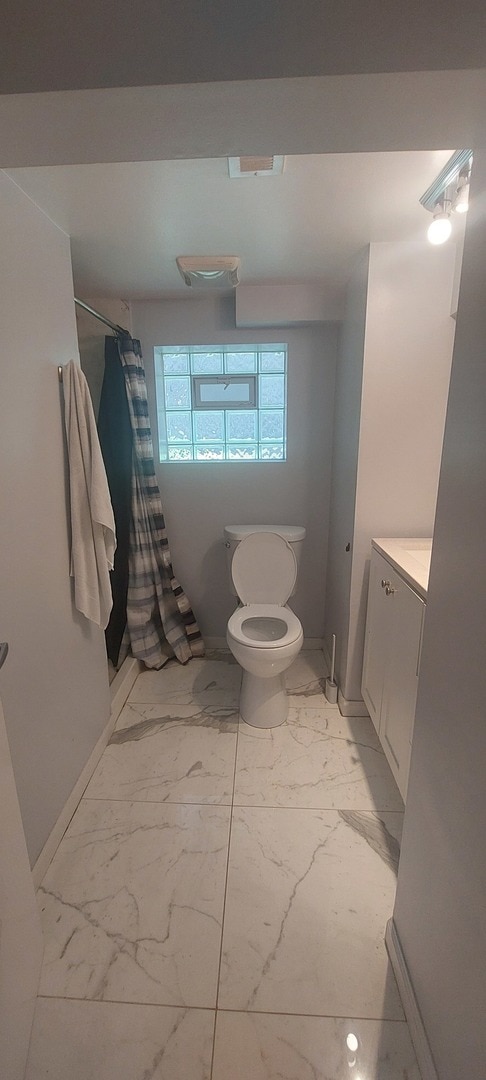 bathroom with tile patterned flooring, toilet, and vanity