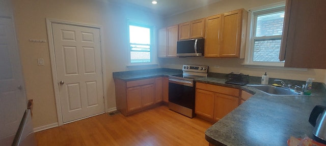 kitchen featuring sink, appliances with stainless steel finishes, and light wood-type flooring