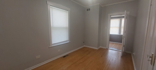 empty room featuring wood-type flooring and ornamental molding