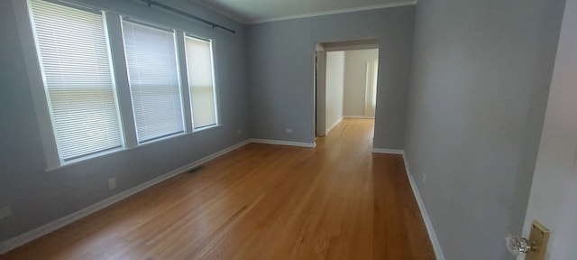 empty room featuring ornamental molding, hardwood / wood-style floors, and plenty of natural light