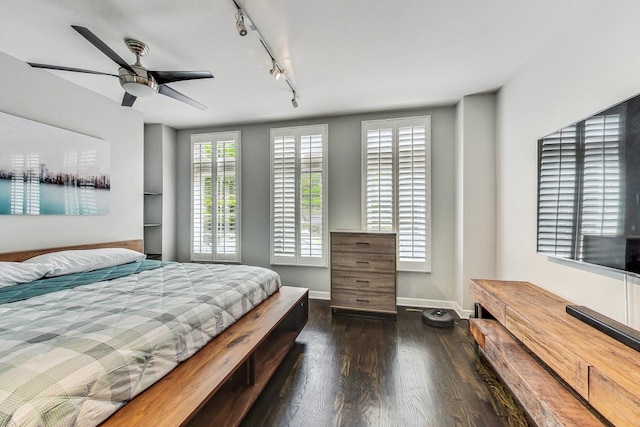 bedroom featuring multiple windows, ceiling fan, track lighting, and dark hardwood / wood-style floors