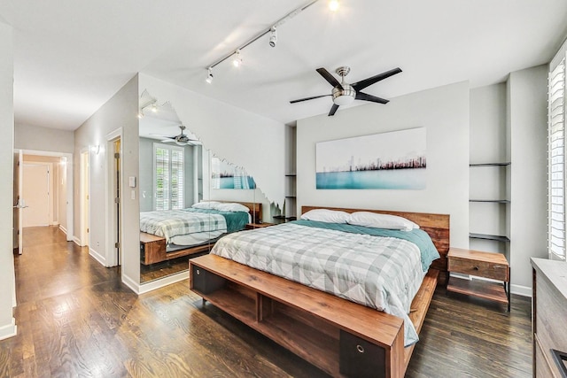 bedroom with dark hardwood / wood-style floors, ceiling fan, and rail lighting