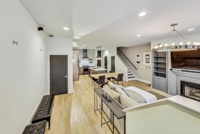 living room with a notable chandelier and light hardwood / wood-style floors