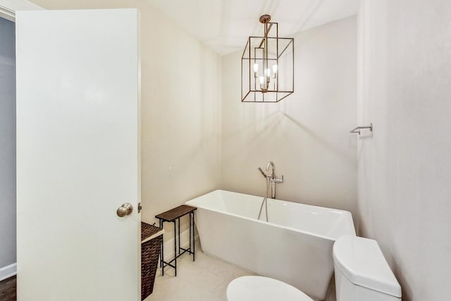 bathroom featuring toilet, a tub, and a notable chandelier