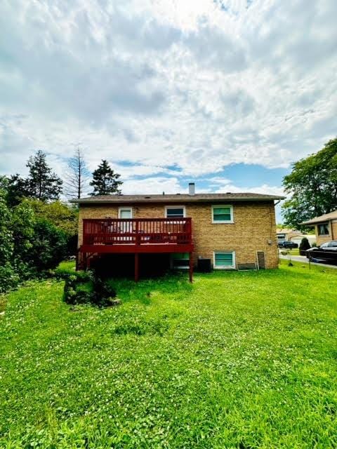 rear view of property with a lawn and a wooden deck