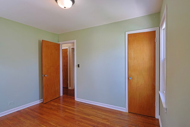 unfurnished bedroom featuring a closet and hardwood / wood-style floors