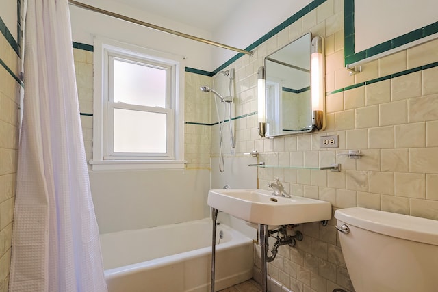 bathroom with toilet, tile walls, and shower / tub combo with curtain