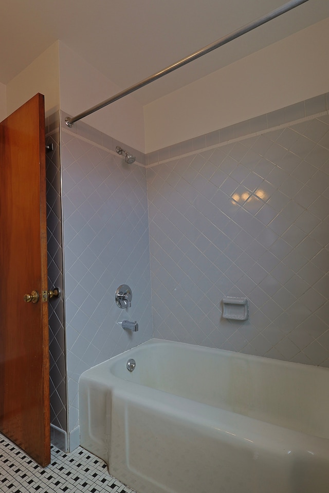 bathroom featuring tiled shower / bath combo and tile patterned flooring