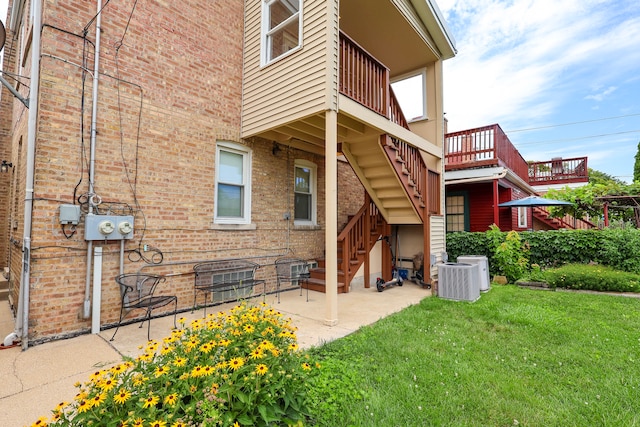 rear view of house featuring a yard, a patio, and central AC