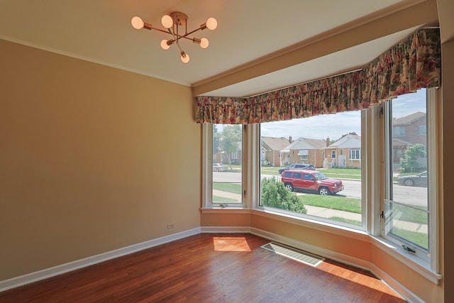 unfurnished dining area with wood-type flooring, a notable chandelier, and ornamental molding