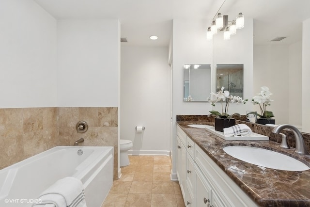 bathroom with a bathing tub, vanity, toilet, and tile patterned floors