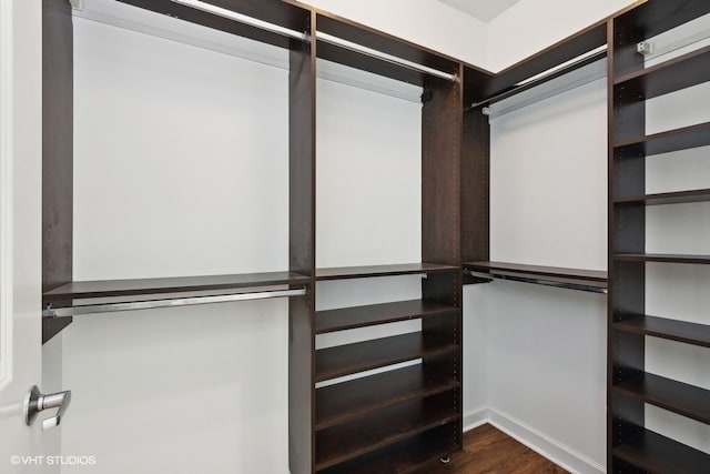 walk in closet with dark hardwood / wood-style floors