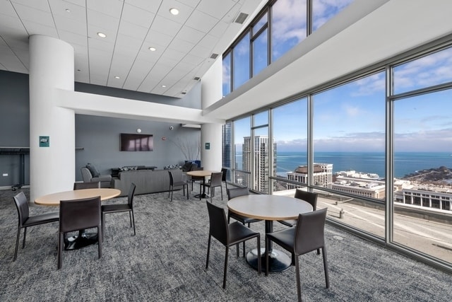 carpeted dining space featuring a towering ceiling and a wealth of natural light