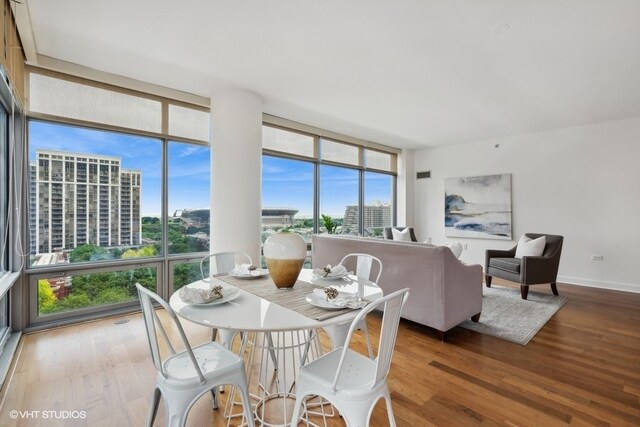 dining space with wood-type flooring and floor to ceiling windows