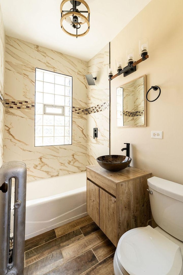 full bathroom featuring vanity, tiled shower / bath, and toilet