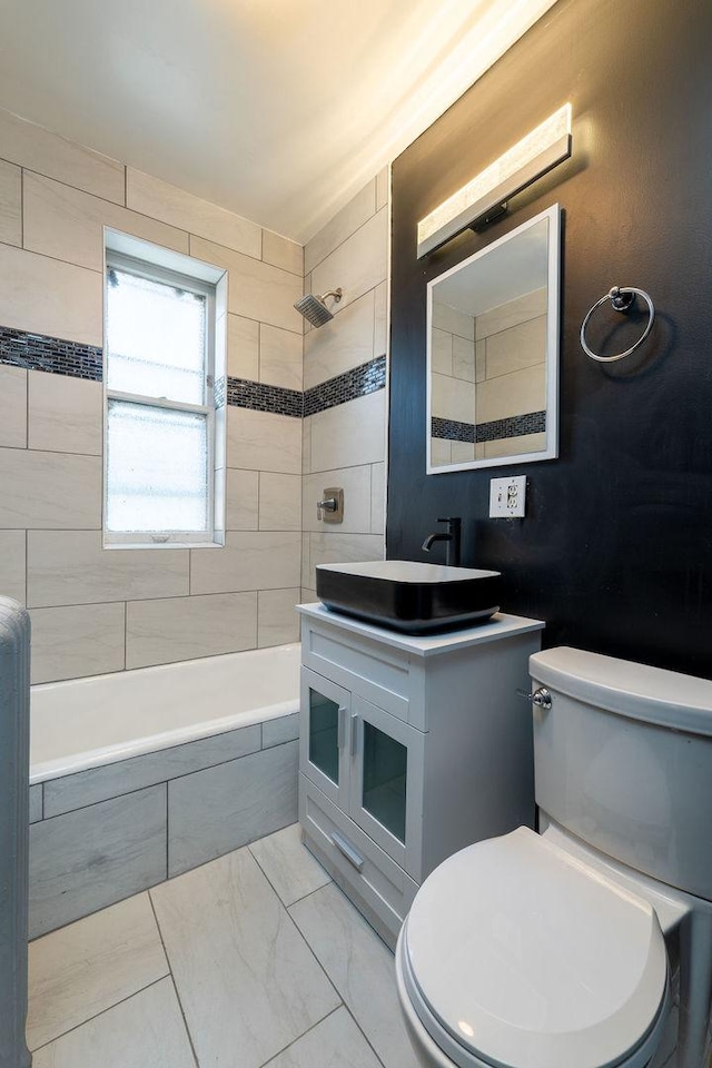 full bathroom with vanity, toilet, and tiled shower / bath